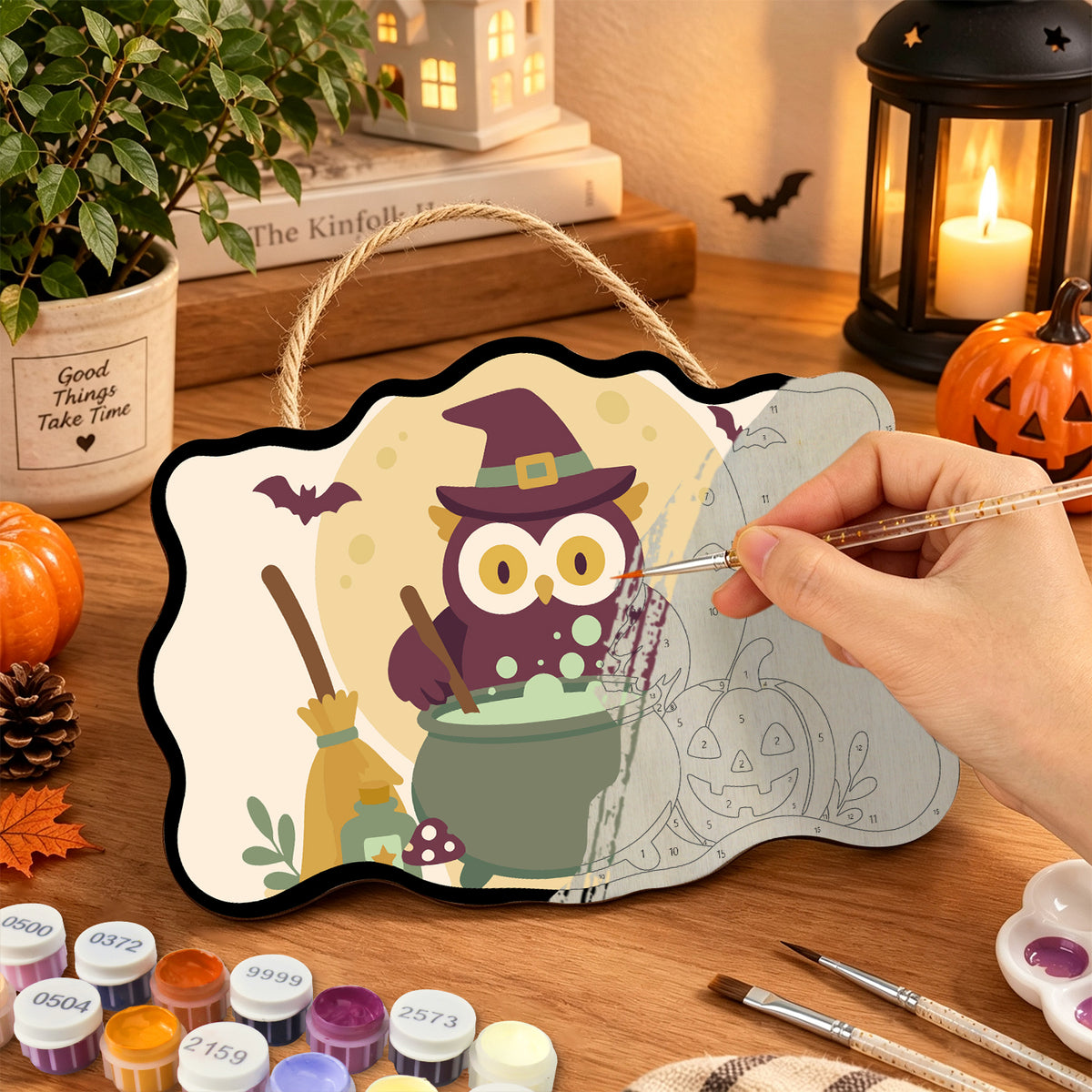 Pancarte Hibou Sorcier et Potion en cours de peinture, pinceau à la main — Maison Artsen