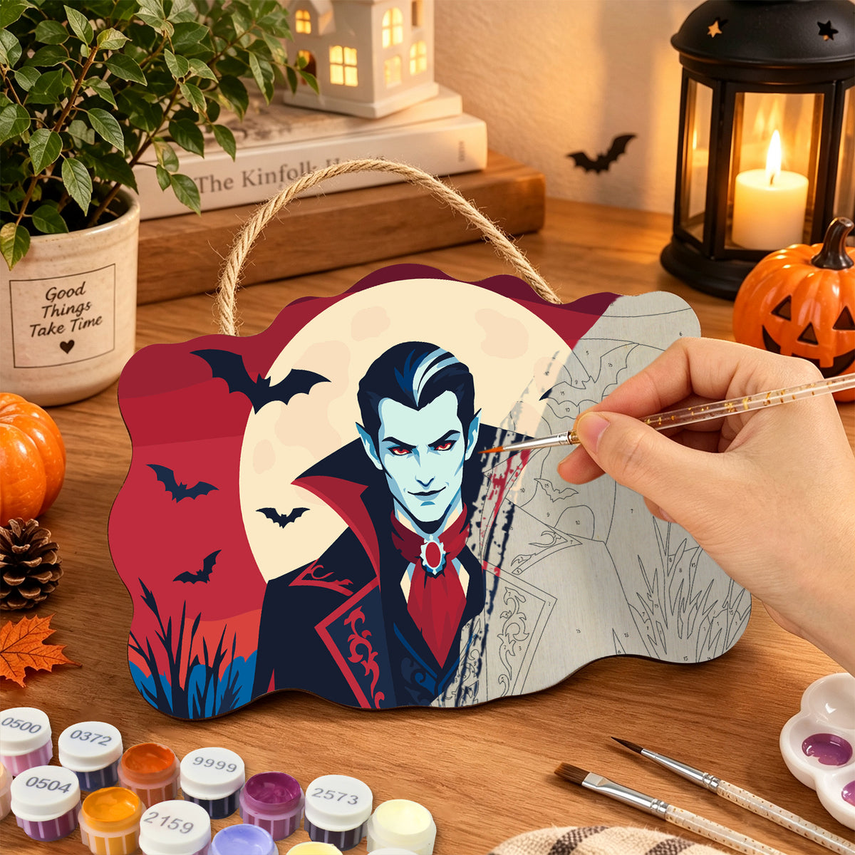 Pancarte Vampire sous la Lune en cours de peinture, pinceau à la main — Maison Artsen